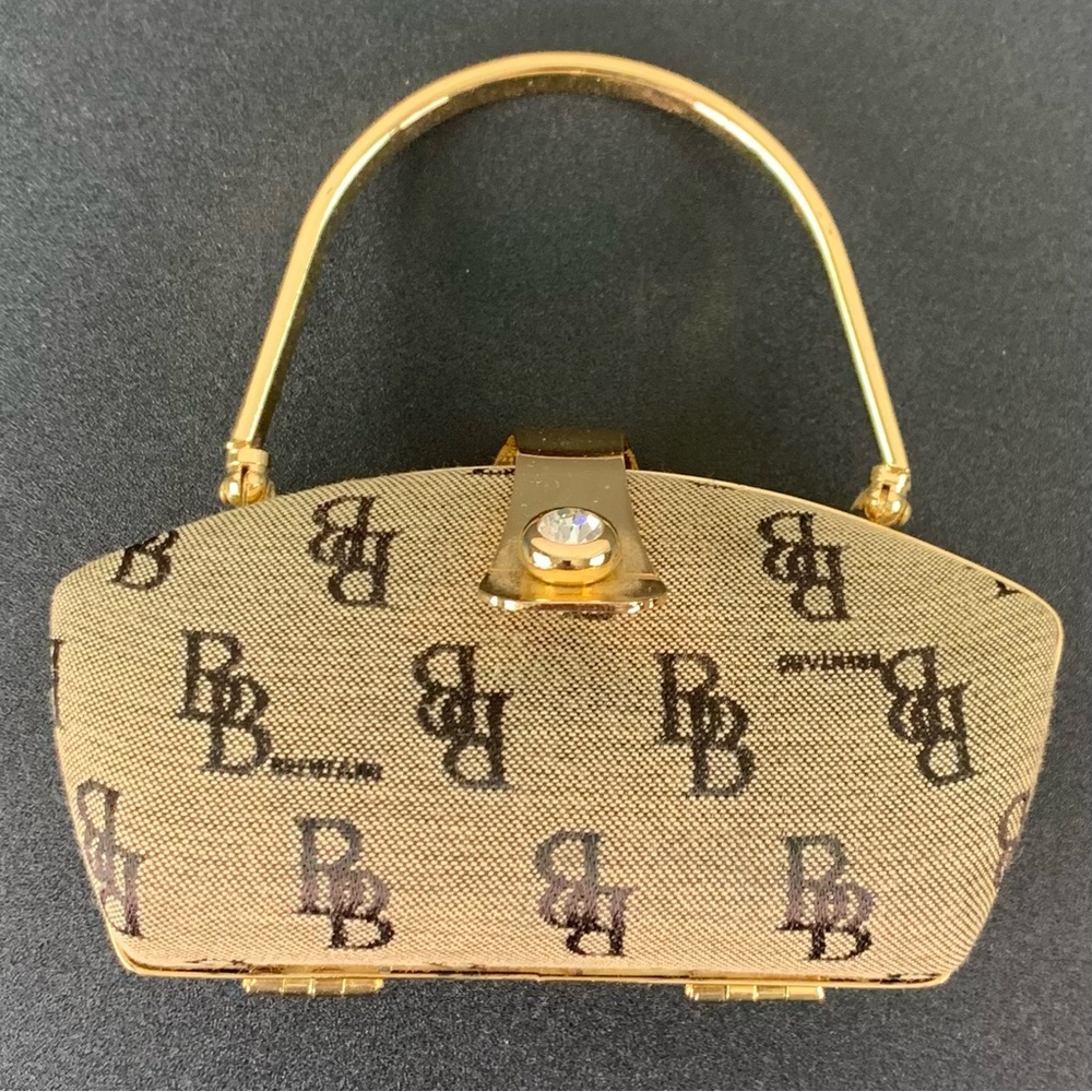 B. Brentano tan and black hard side mini purse.
